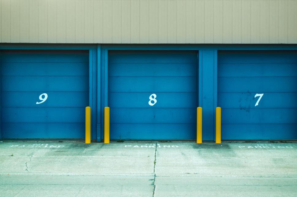 Free Image of Garage doors numbered 9, 8, and 7 painted in blue shade. 