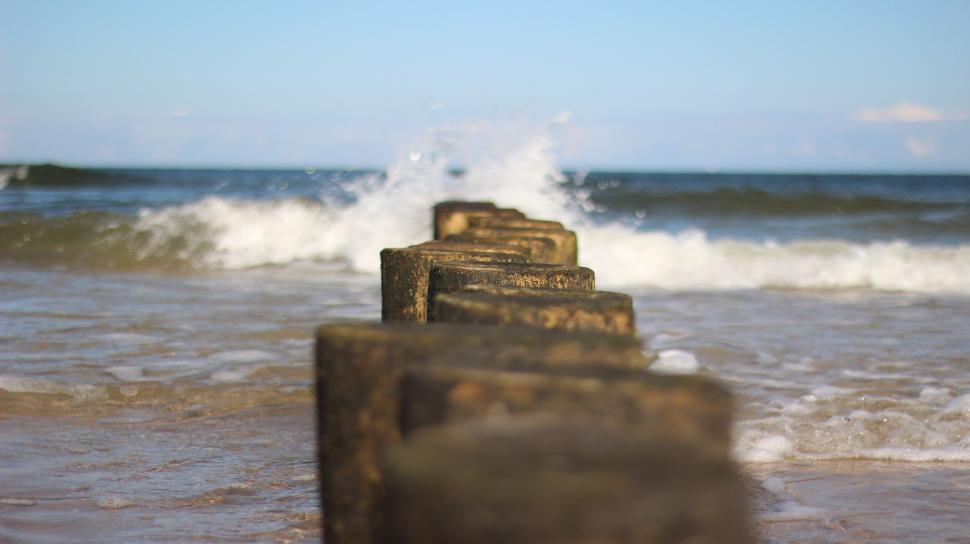 Free Image of Seascape with wooden pillars stretching into horizon. 
