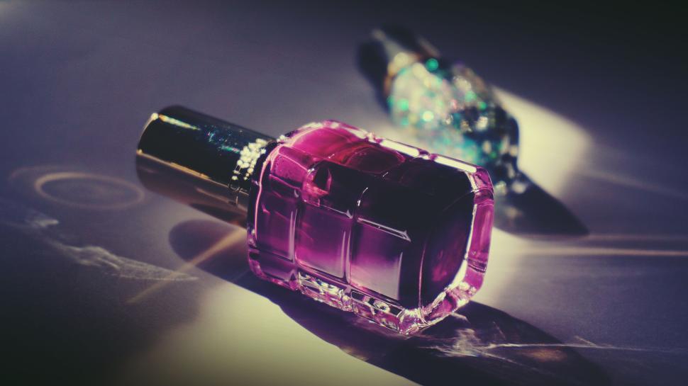 Free Image of Close-up of purple nail polish bottle on a dark surface. 