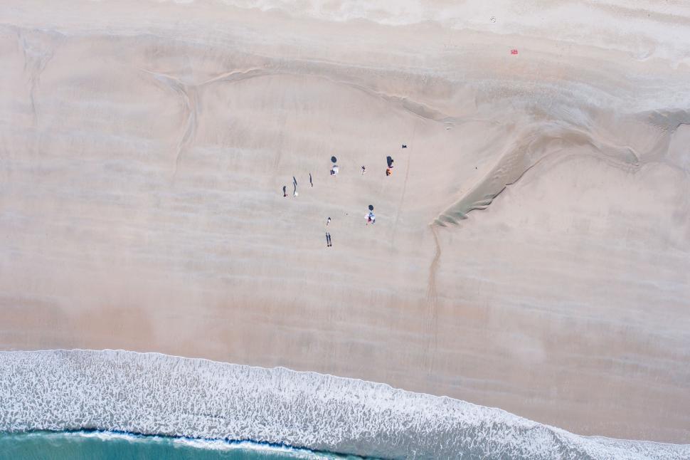 Free Image of Aerial view of people relaxing on a sandy beach. 
