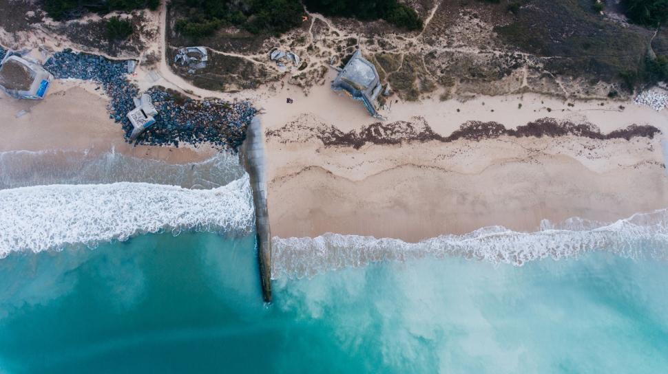 Free Image of Aerial view of tranquil beach with waves and rocks 