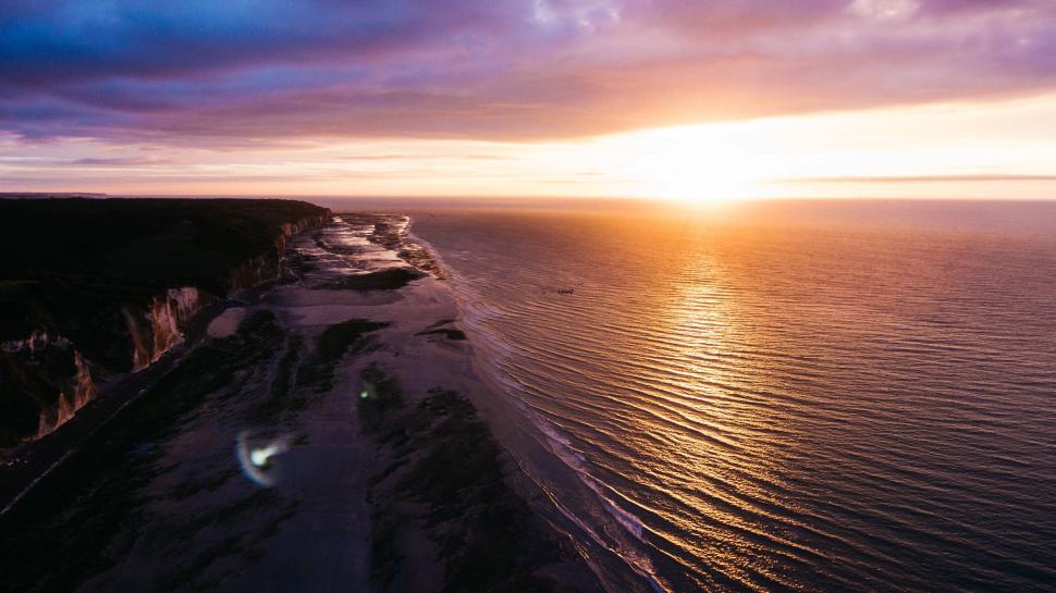 Free Image of Serene ocean sunset with radiant sky reflecting water 