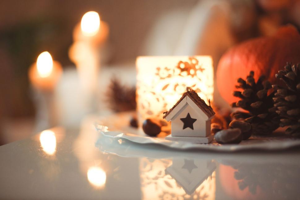 Free Image of Cozy warm candle-lit decor with small wooden house. 