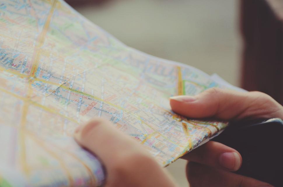 Free Image of Close-up of hands holding a folded map for directions 