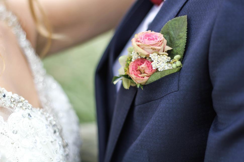 Free Image of Groom in suit with elegant pink rose boutonniere. 