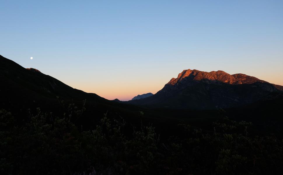 Free Image of Scenic mountain view at sunrise with moon in the sky 