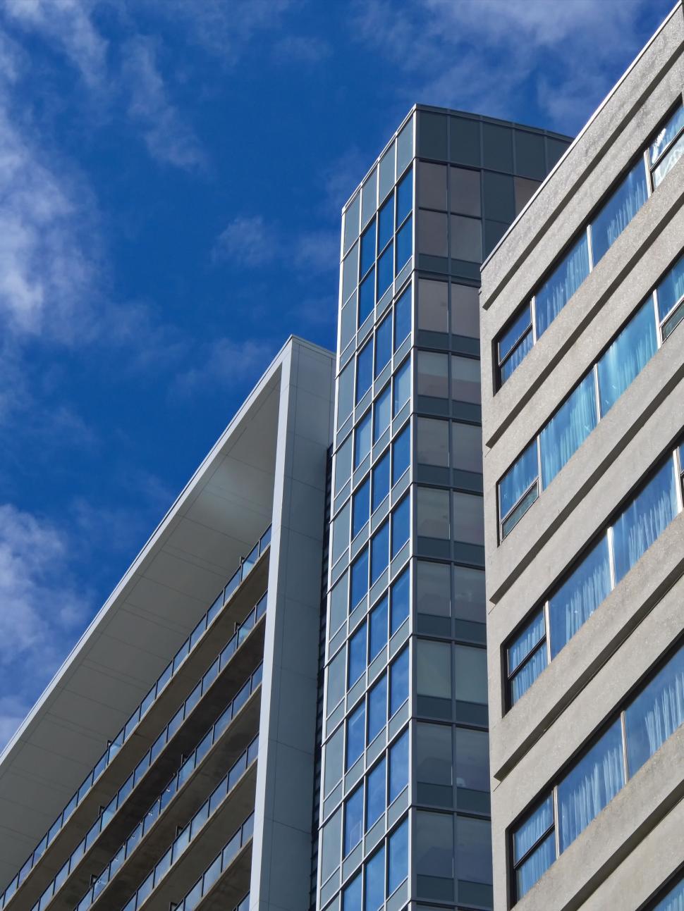 Free Image of Modern skyscraper with glass facade reaching towards the sky. 