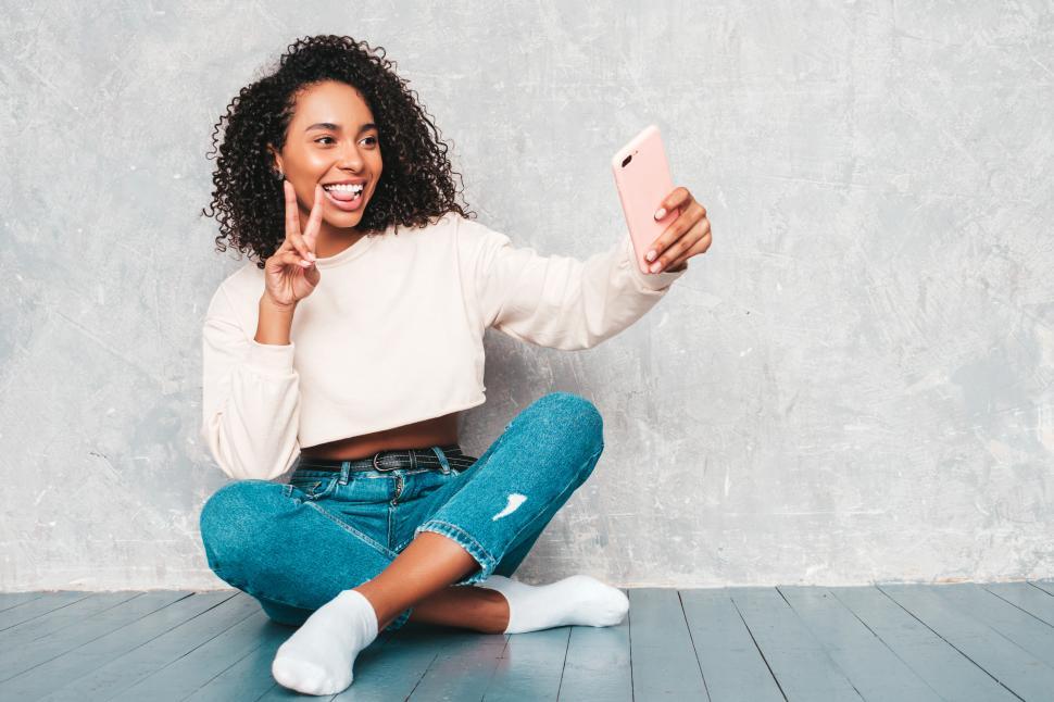 Free Image of Woman taking selfie while sitting on floor, indoors 
