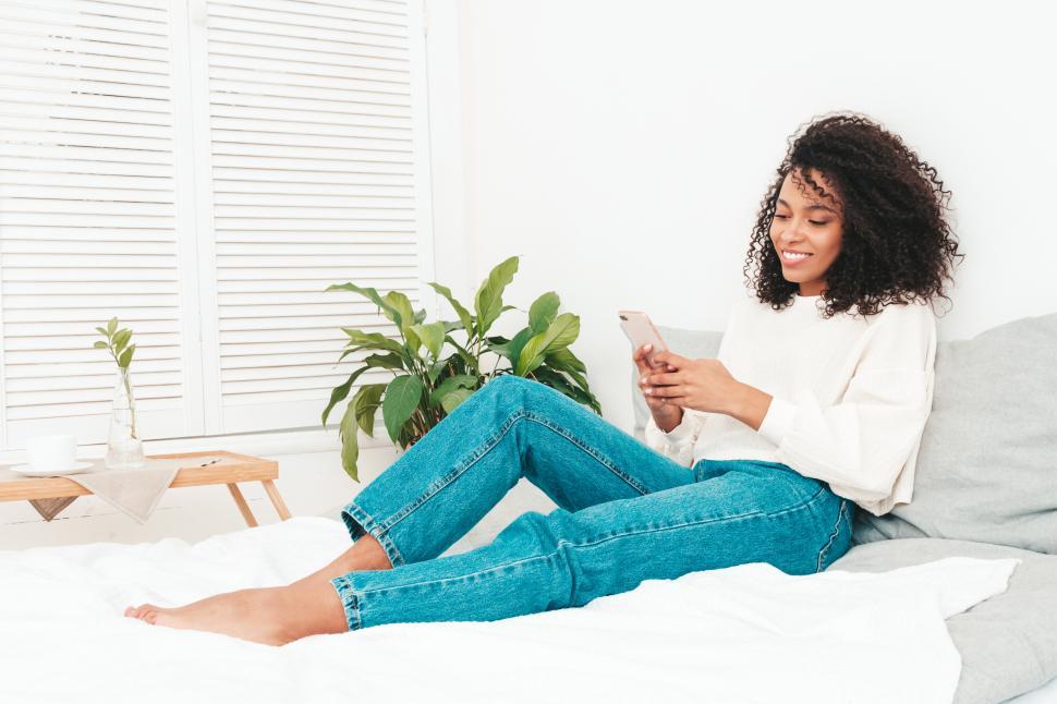 Free Stock Photo of Woman relaxing on bed with phone in cozy room. |  Download Free Images and Free Illustrations