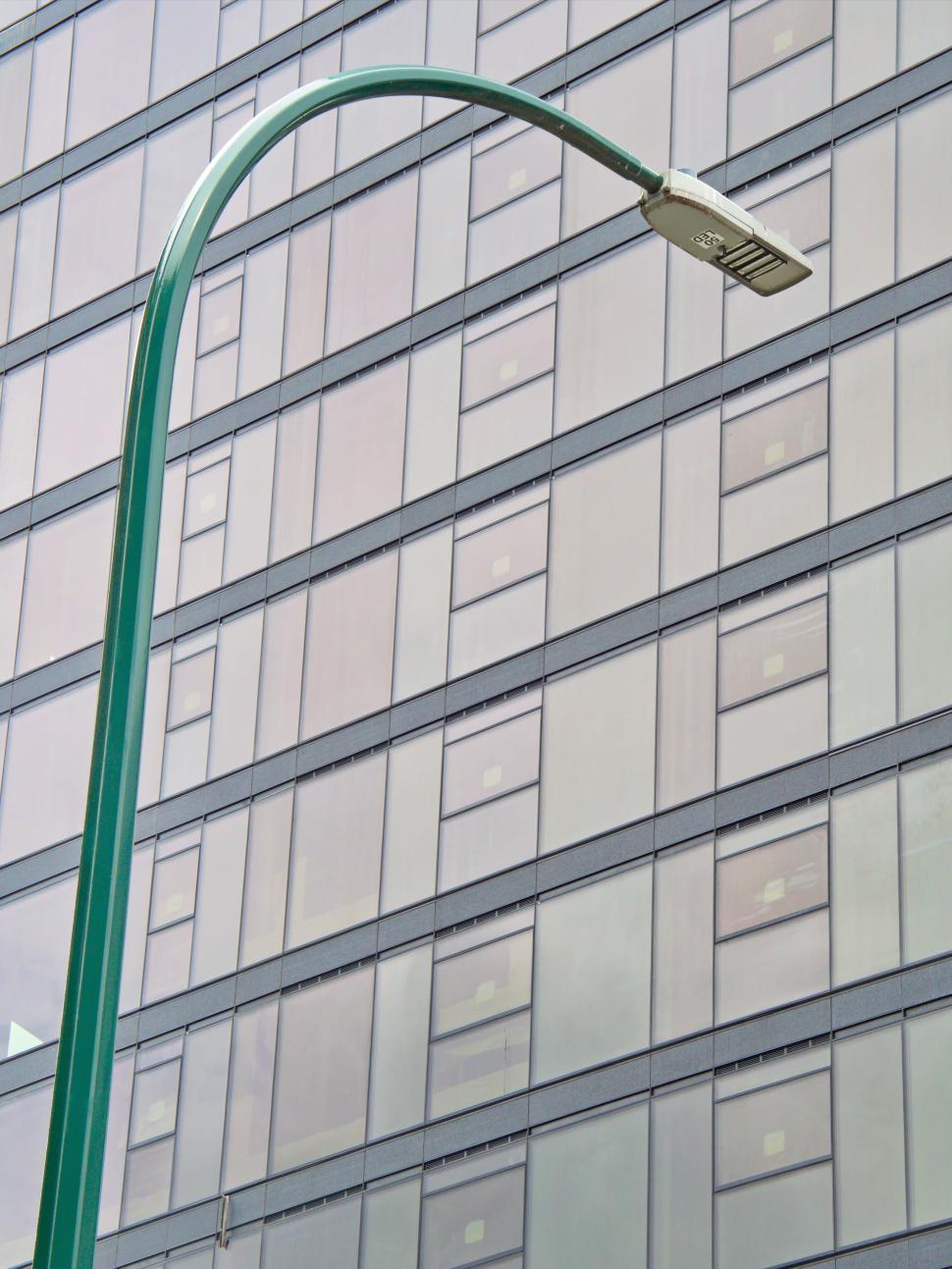 Free Image of Modern building with green street lamp in foreground 