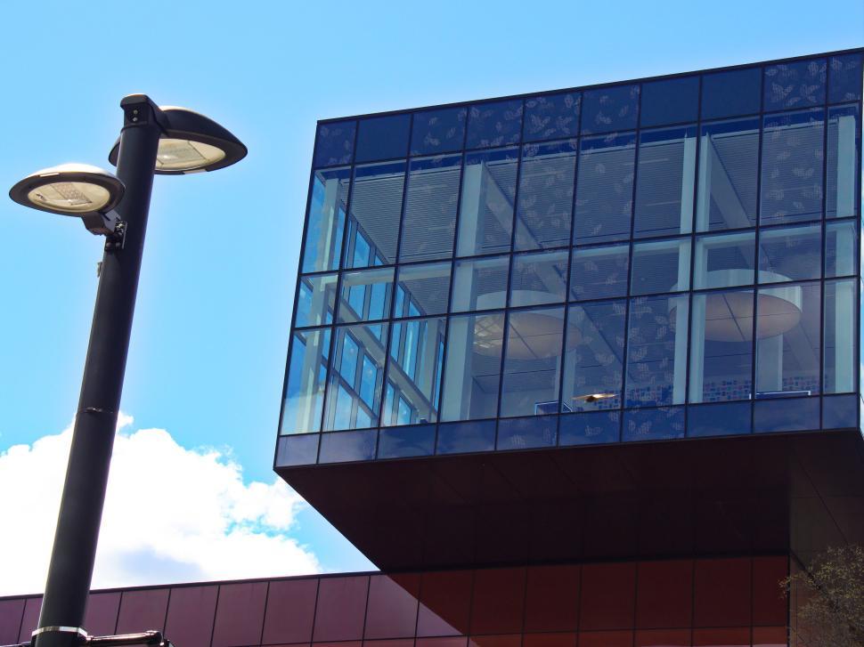 Free Image of Modern glass office building with extended upper section 