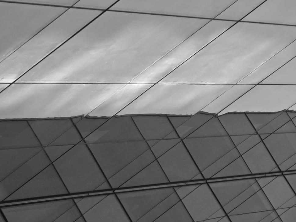 Free Image of Abstract geometric glass facade reflecting sky view. 