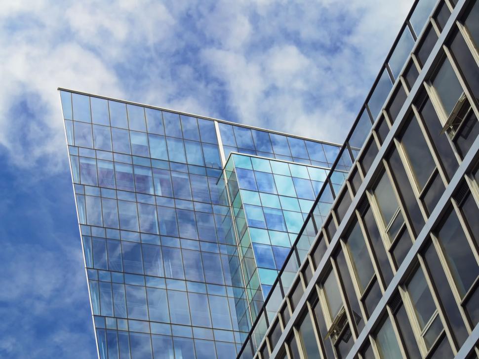 Free Image of Sharp-edged modern glass building against cloudy sky 