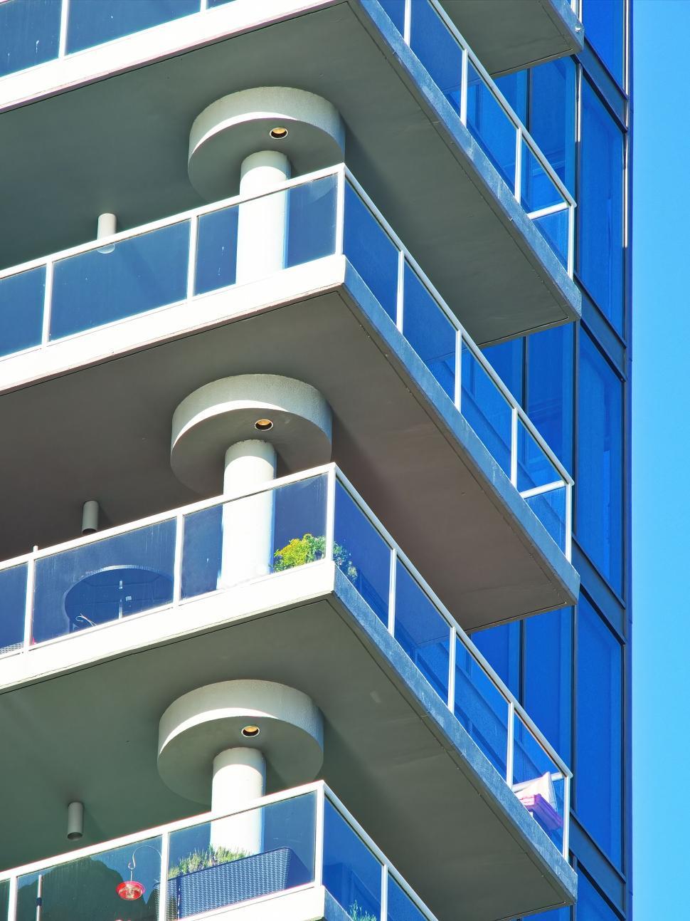 Free Image of Building with glass balconies and cylindrical pillars 