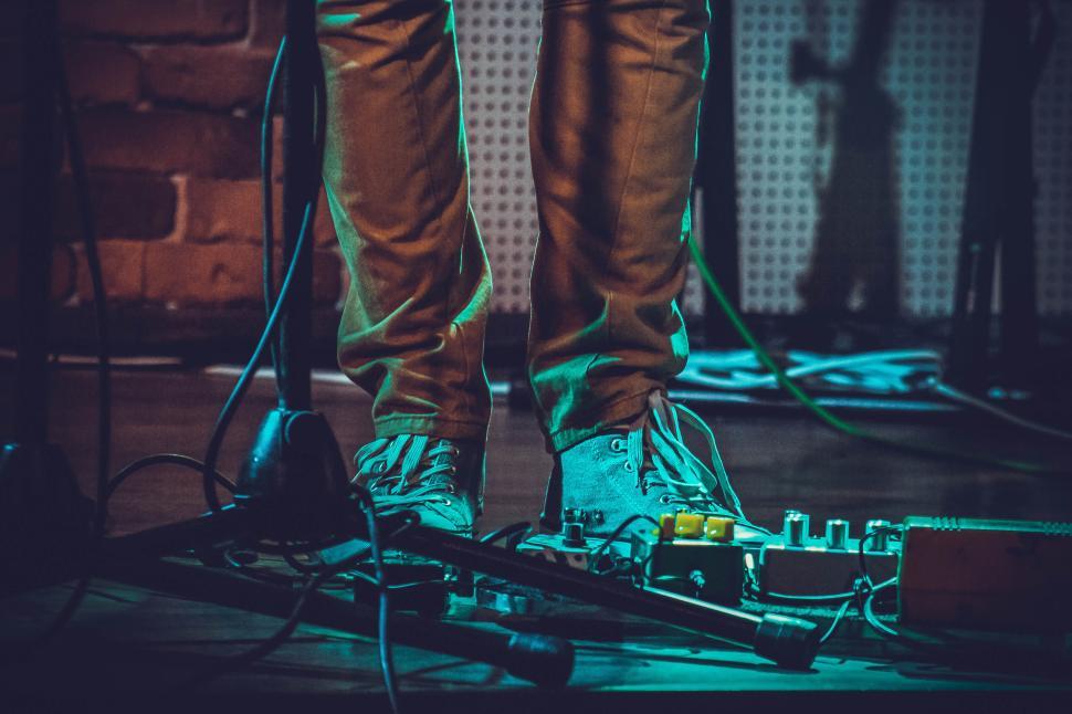 Free Image of Musician s feet next to guitar pedals on stage 