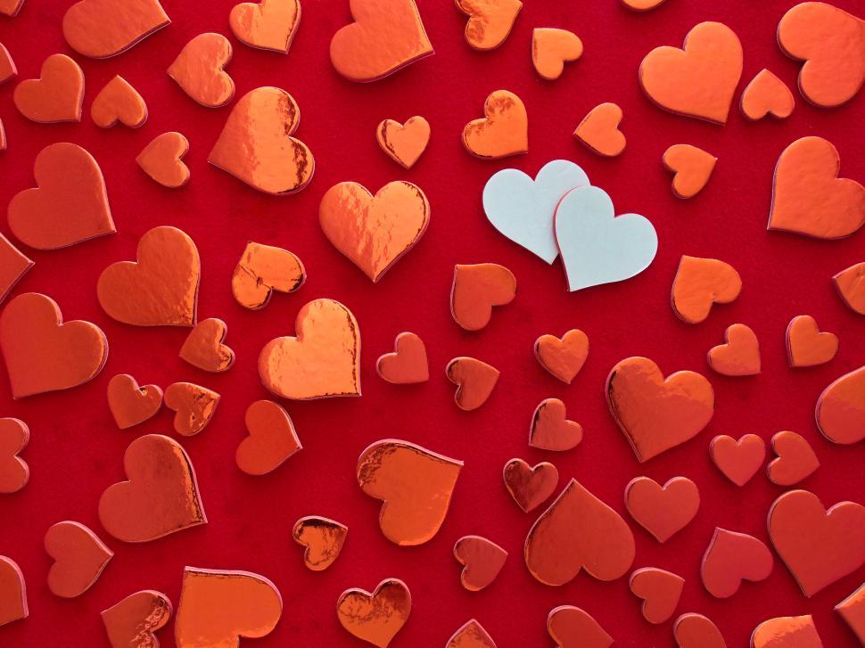 Free Image of Red and white hearts scattered on red background close-up 