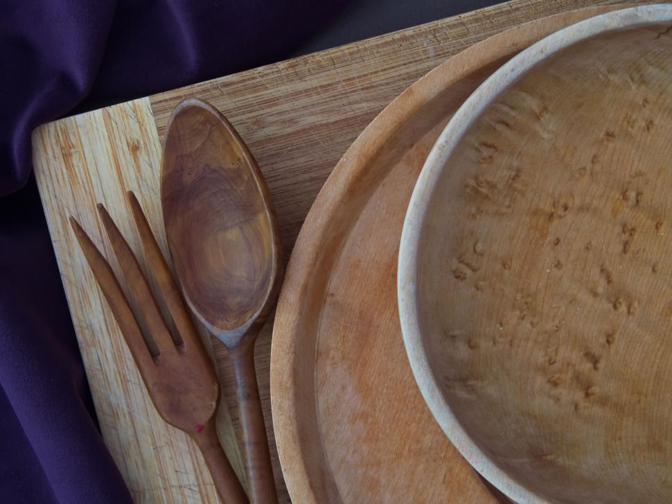 Free Image of Wooden utensils on a cutting board with purple fabric 