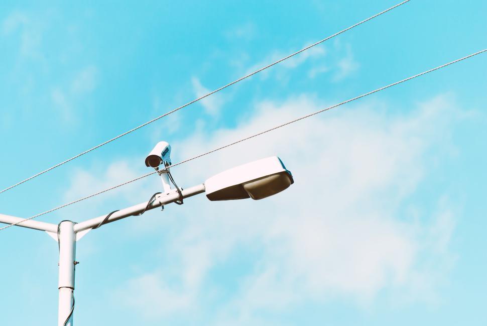 Free Image of Street lamp and camera against a blue summer sky 