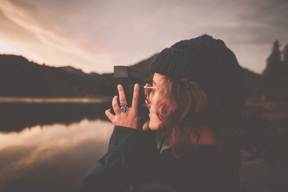Free Image of Person taking a photograph of the serene lake at sunset 