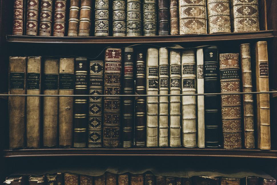Free Image of Antique bookshelf filled with old, ornate books. 