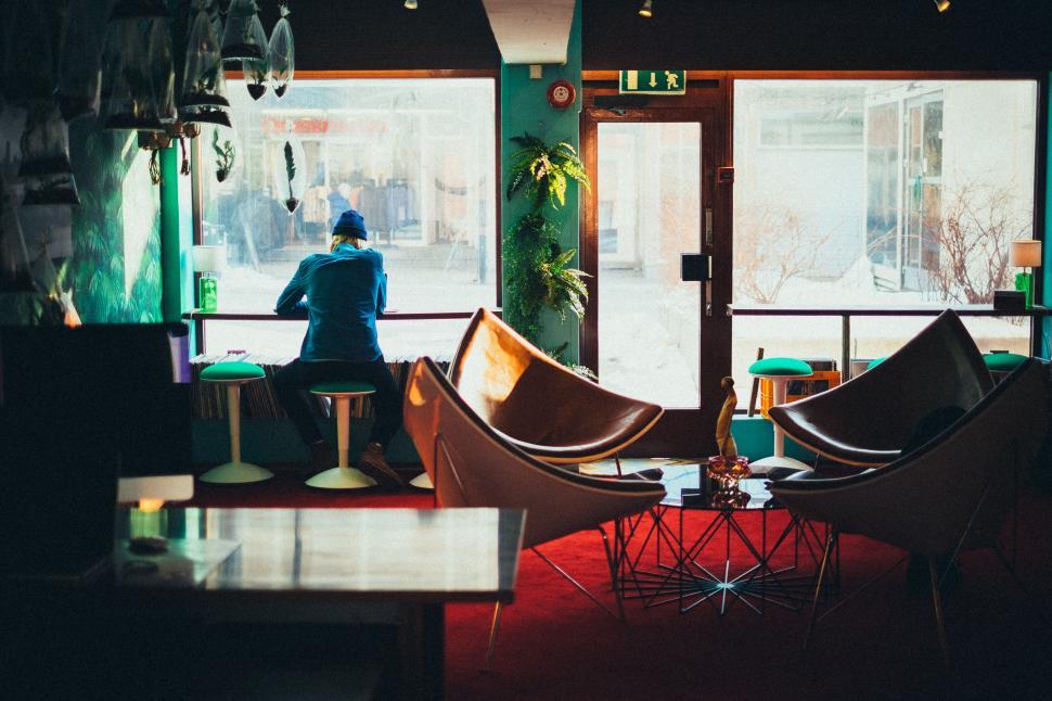Free Image of Lone figure in a quiet, art-design coffee shop 
