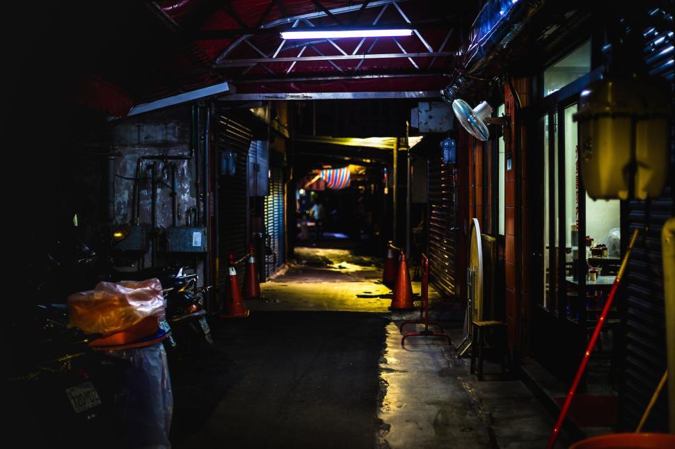 Free Image of Dimly lit narrow alleyway illuminated by overhead lights 