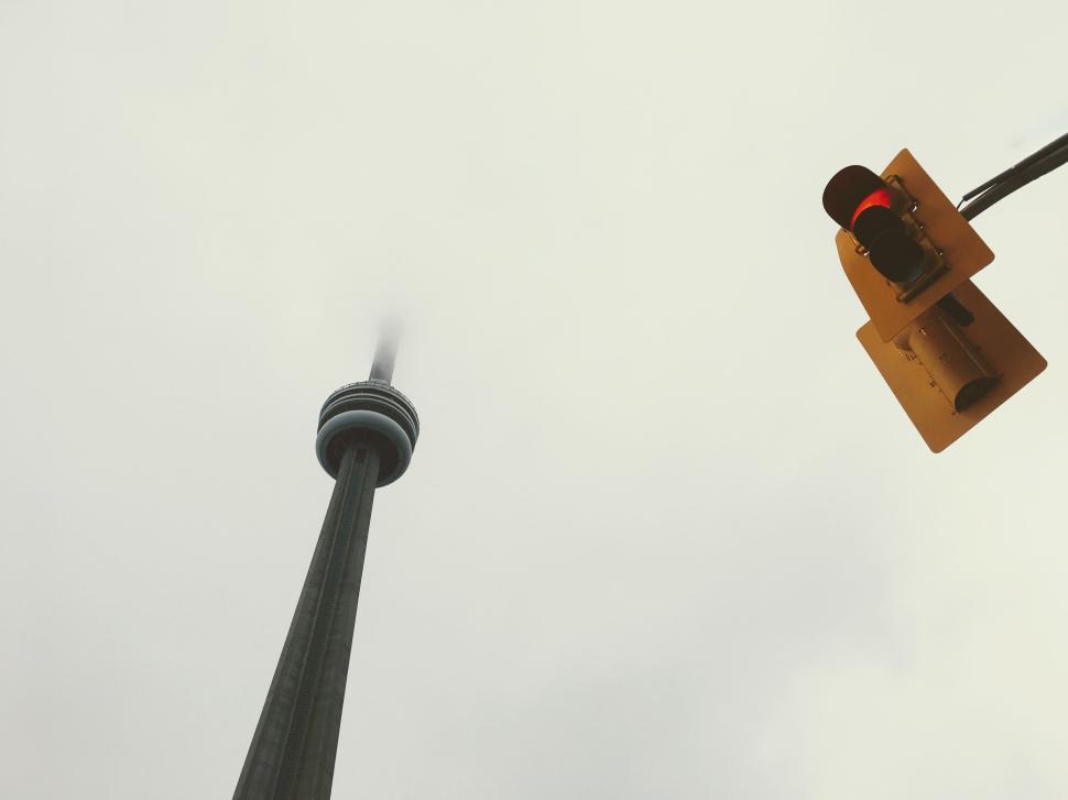 Free Image of CN Tower and traffic light under cloudy sky. 