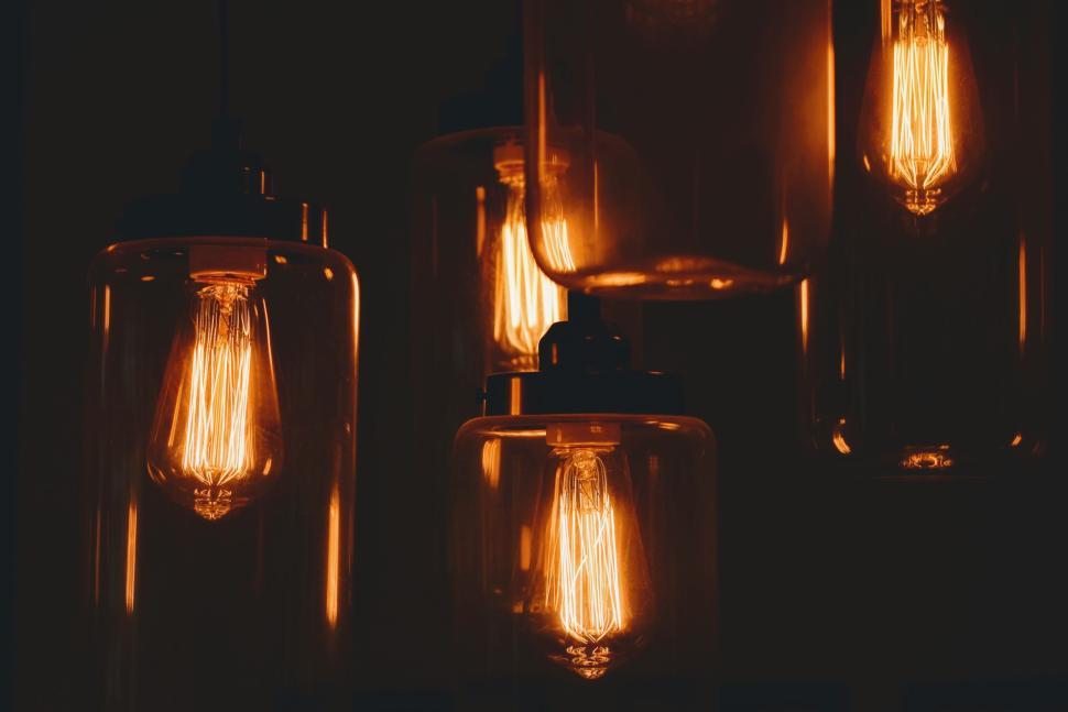 Free Image of Glowing filament bulbs in glass lamps in the dark. 
