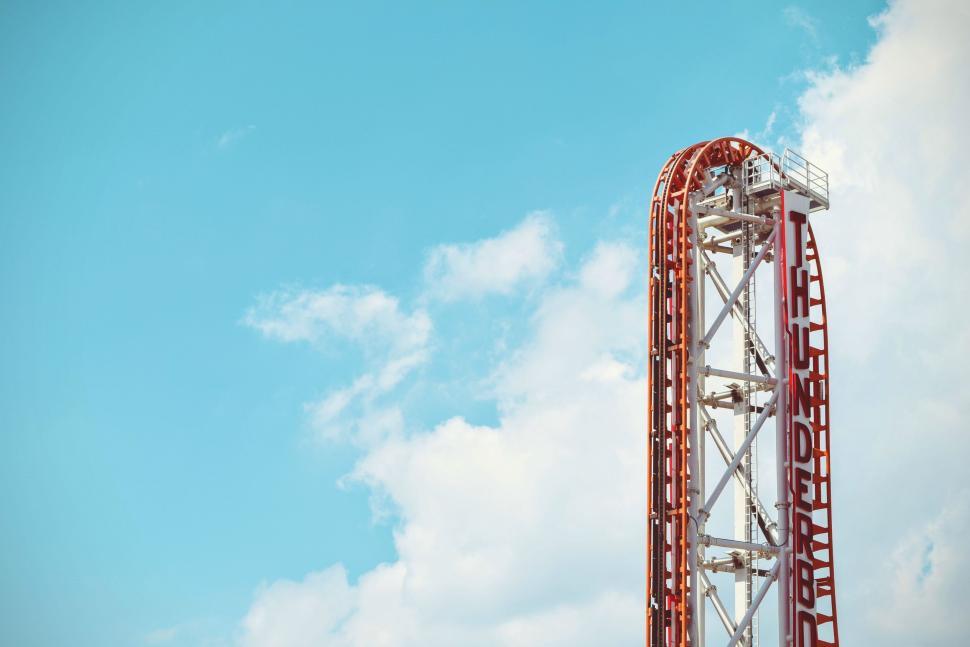 Free Image of Colorful roller coaster track loop against a blue sky. 