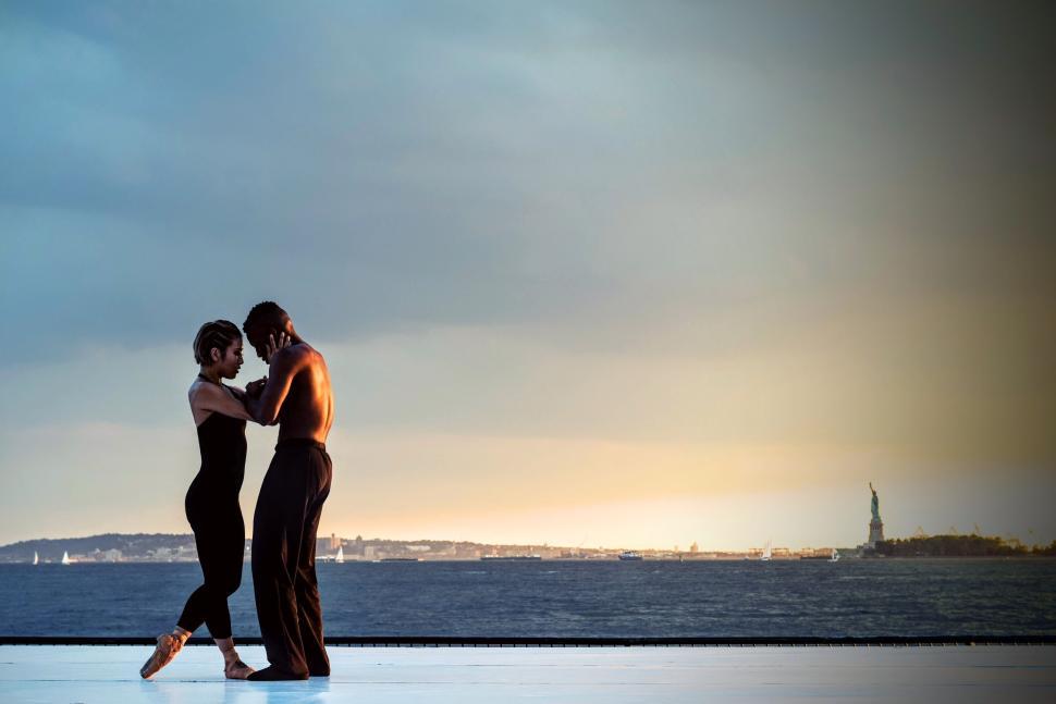 Free Image of Couple dancing with scenic backdrop and sunset view. 