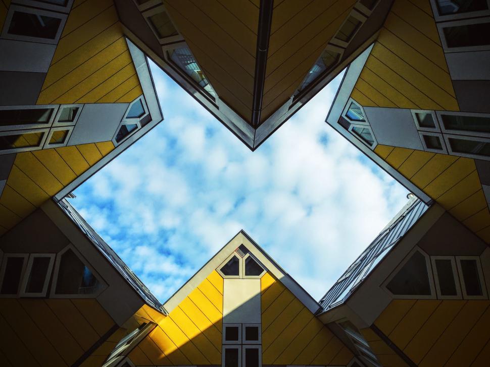 Free Image of Geometric yellow building with sky view through center 