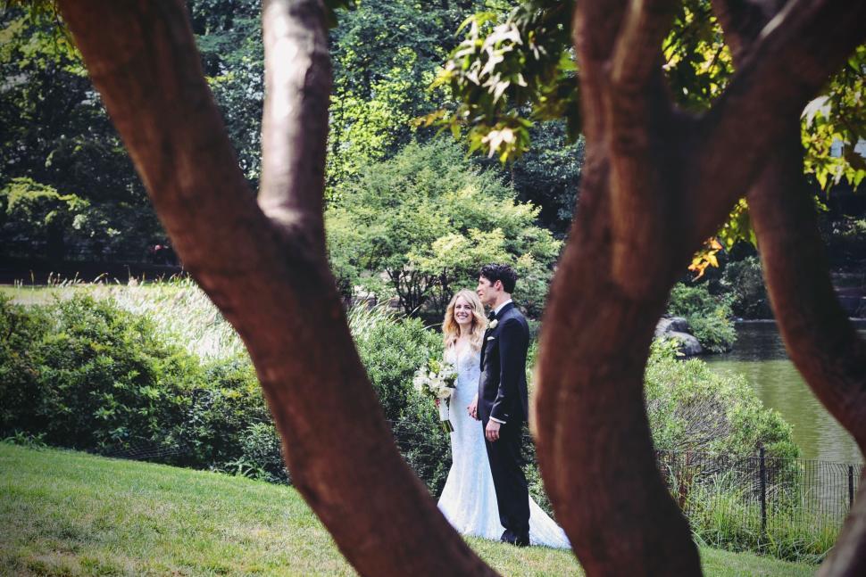 Free Image of Bride and groom sharing moment in lush green park setting. 