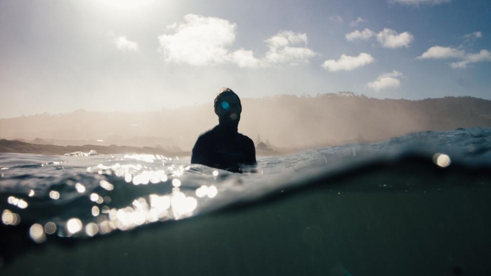 Free Image of Silhouette in ocean during sunrise with distant horizon 