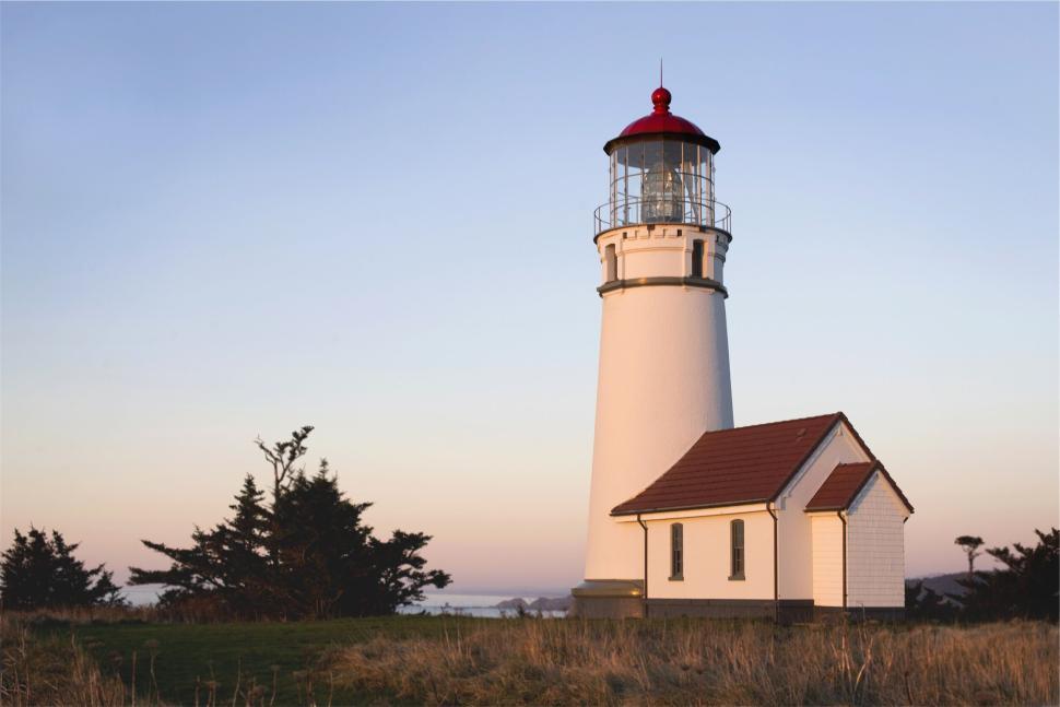 Free Image of White lighthouse with red dome under clear skies at dusk 