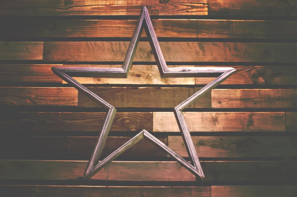 Free Image of Metal star against wood wall background with lights. 