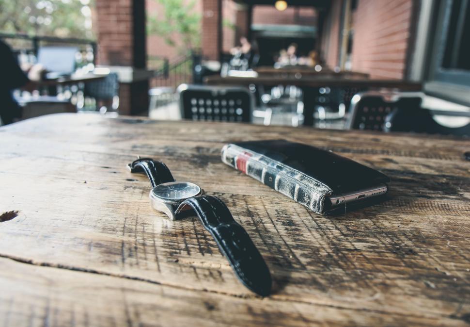 Free Image of Leather watch and phone case on rustic wooden table 