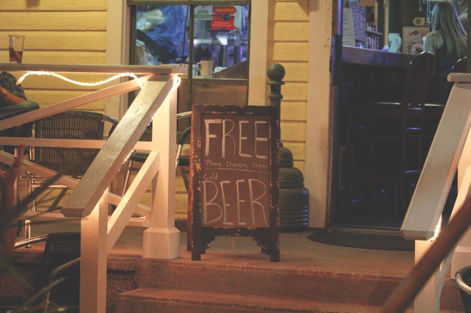 Free Image of Chalkboard sign on steps advertising free beer outside. 