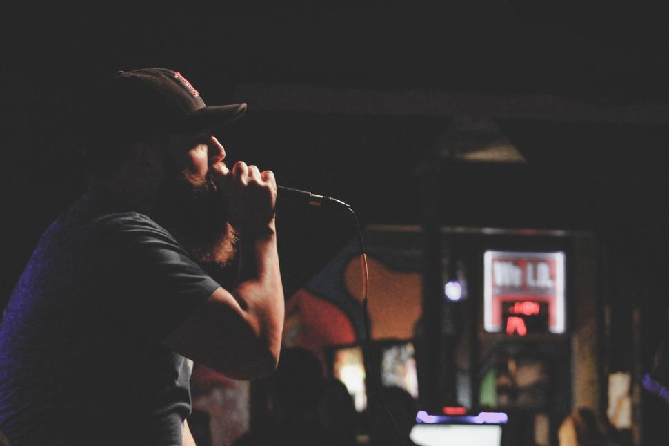 Free Image of Person singing passionately into a microphone on stage 