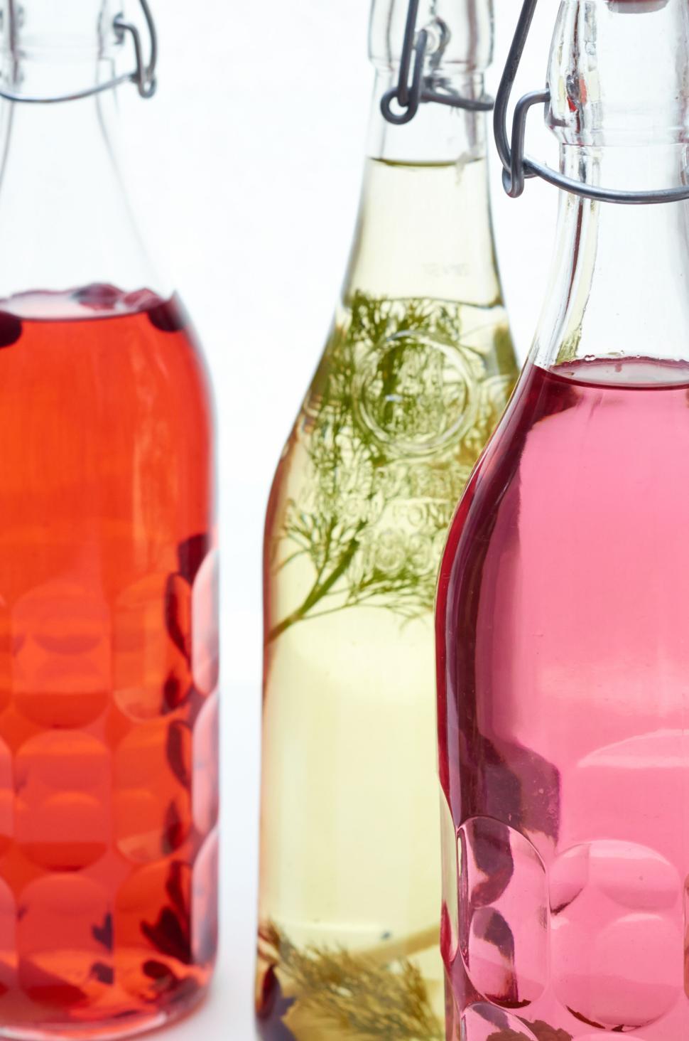 Free Image of Close-up of three bottles with colorful drinks inside them 