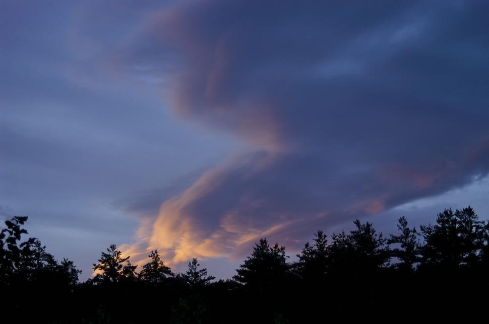 Free Image of Dramatic clouds during twilight over silhouetted trees 