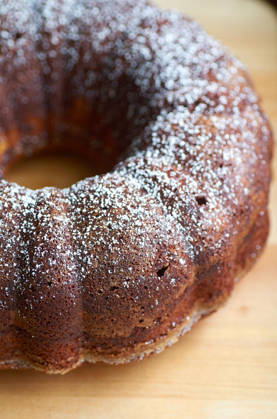 Free Image of Delicious bundt cake topped with powdered sugar on table 