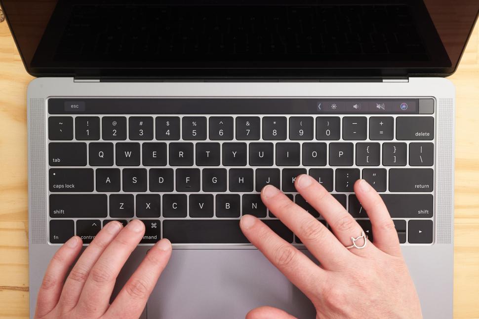hands-typing-on-a-modern-laptop-with-wooden-background.jpg