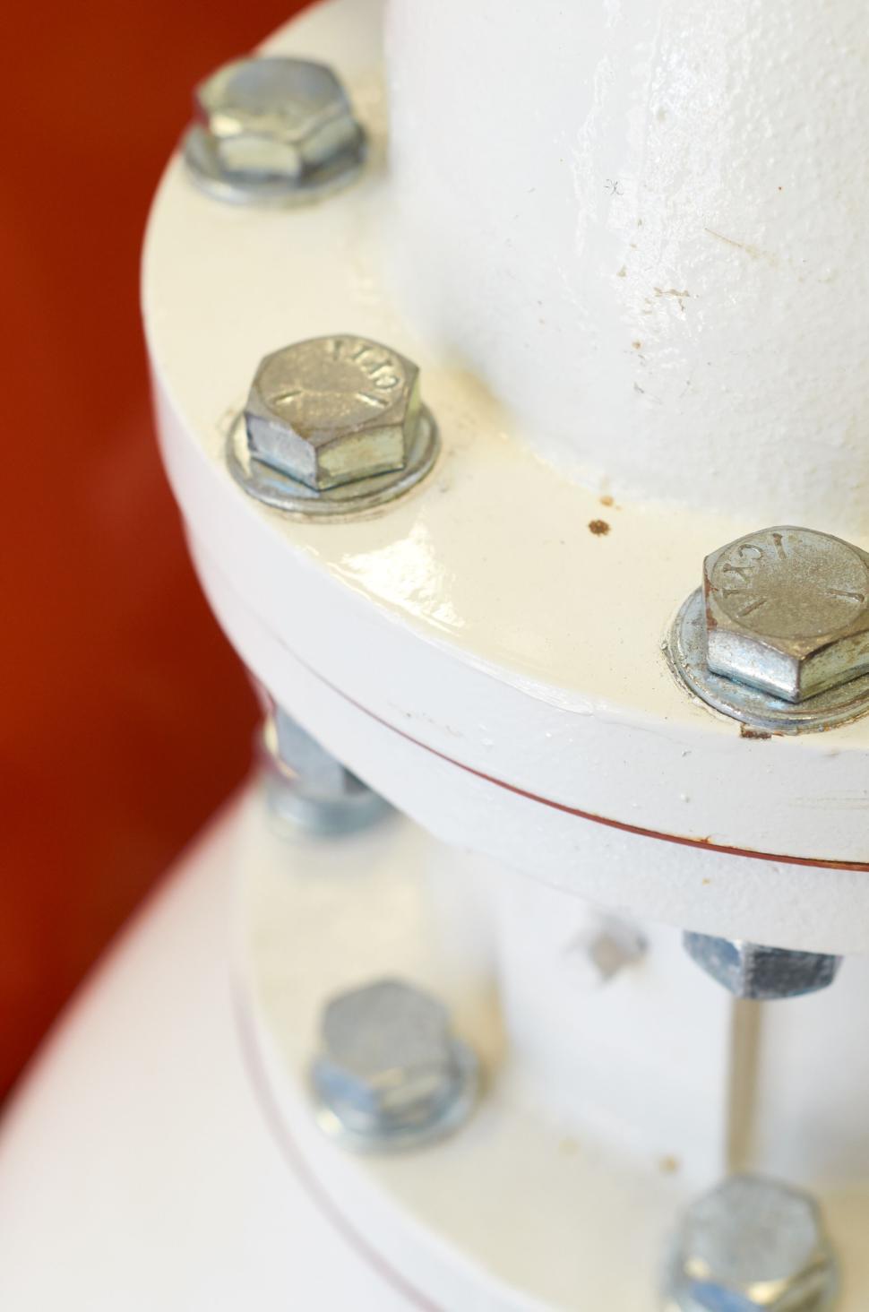 Free Image of Close-up of industrial bolts and white metal equipment 