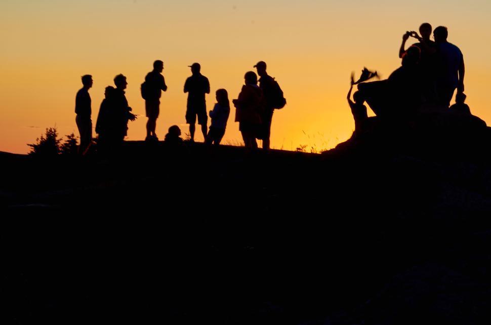 Free Image of Silhouetted group of people at sunset on a hilltop 