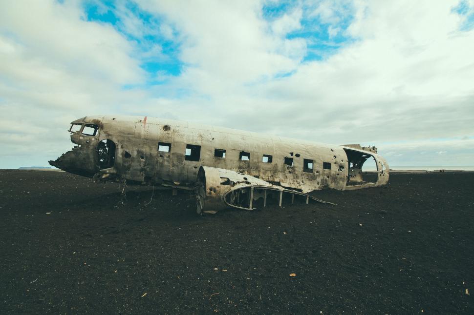 Free Image of Crumbled airplane wreckage in desolate landscape scene. 