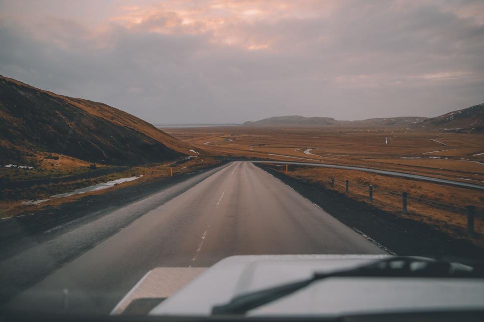Free Image of Empty road winding through hilly landscape at dusk. 