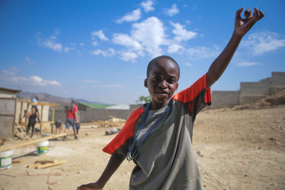 Free Image of Child joyfully playing on construction site under clear sky 