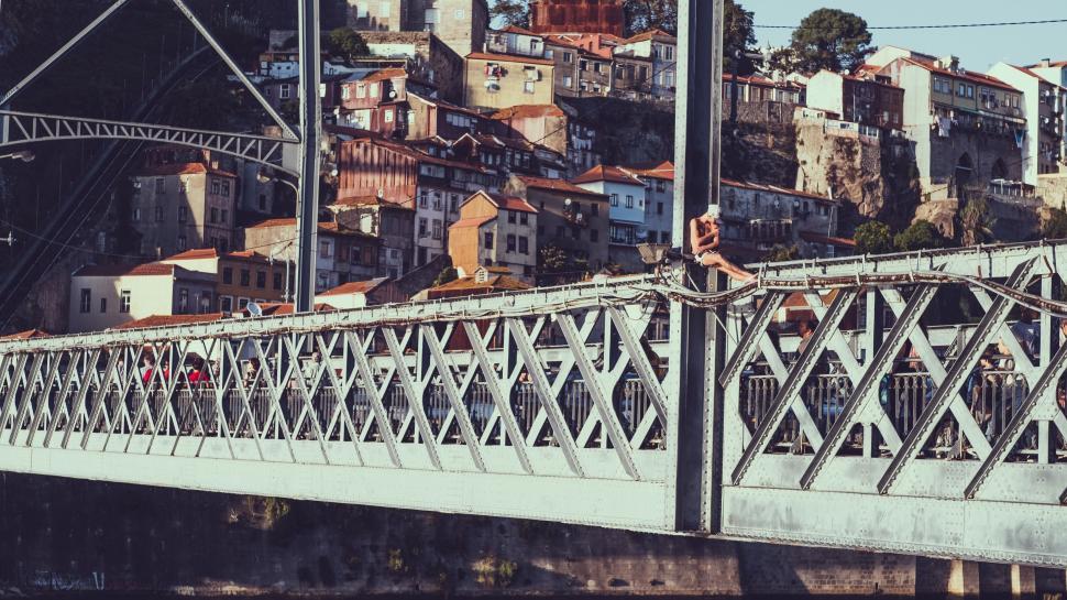 Free Image of Steel bridge over water set against colorful buildings 