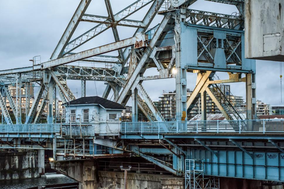 Free Image of A large metal bridge spanning an urban waterway 