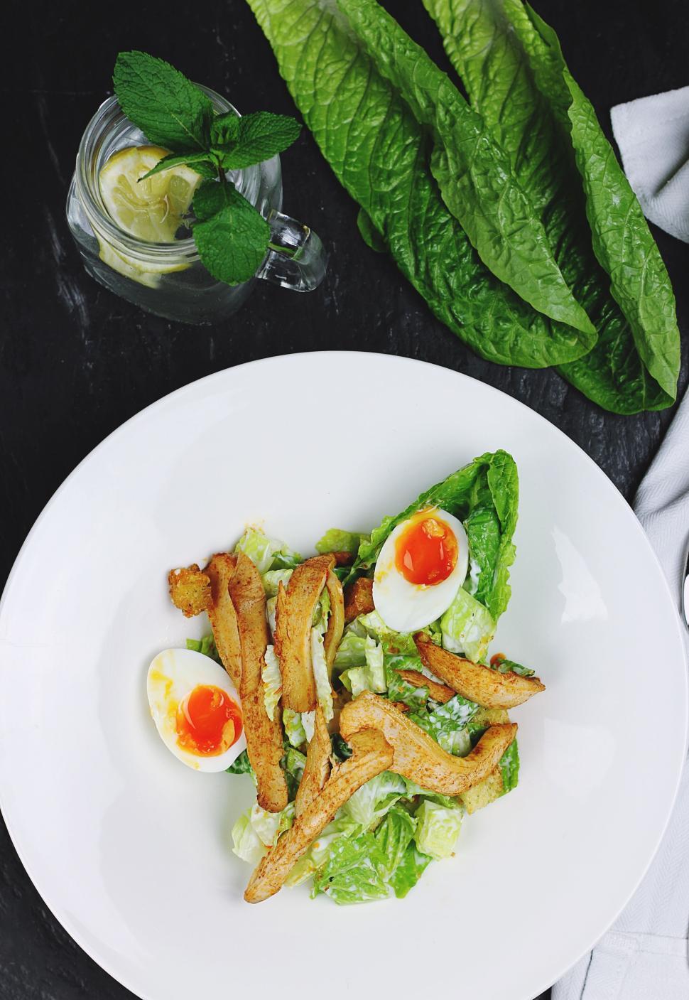 Free Image of Chicken Caesar salad with poached egg on a white plate 
